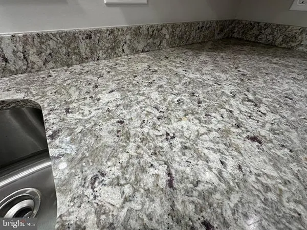 a kitchen with stainless steel appliances granite countertop a sink a stove a refrigerator and a center island