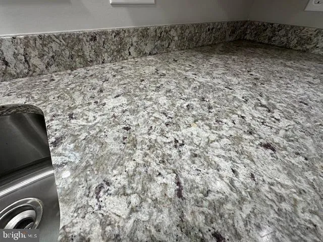 a kitchen with stainless steel appliances granite countertop a sink a stove a refrigerator and a center island