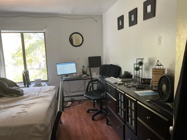 a view of a workspace with furniture and a window