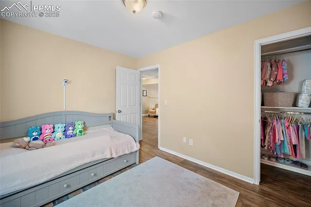 a bedroom with a large bed and painting on the wall