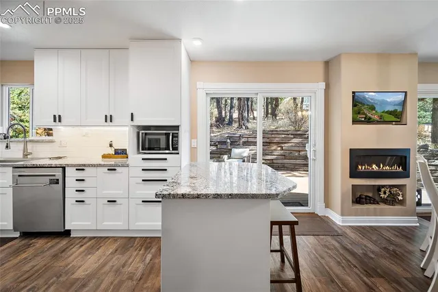a kitchen with granite countertop white cabinets and white appliances