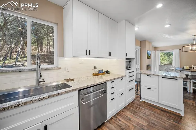 a kitchen with granite countertop a refrigerator and a sink