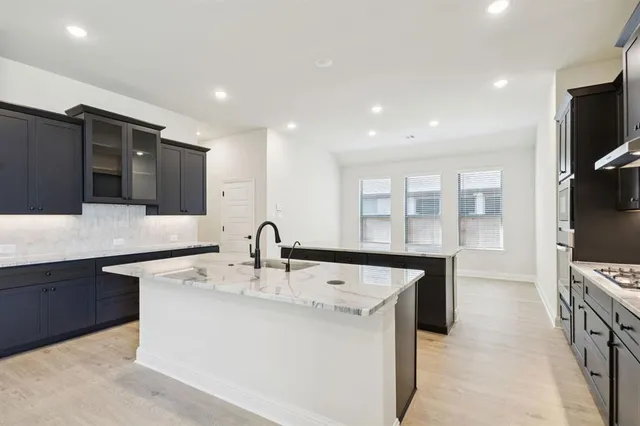 a kitchen with stainless steel appliances granite countertop a sink and a refrigerator