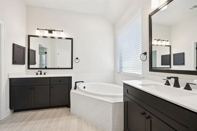 a bathroom with a tub sink and mirror
