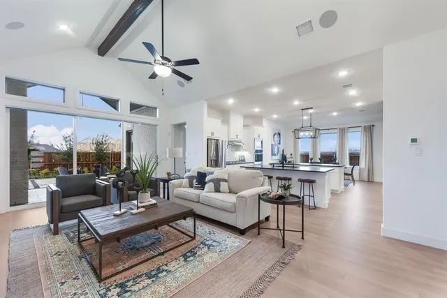 a living room with furniture kitchen view and a large window