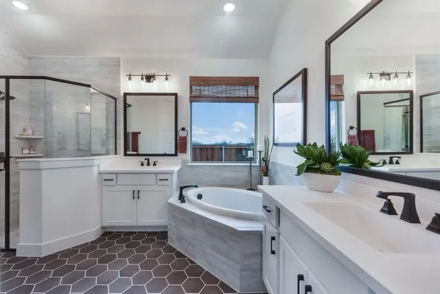 a bathroom with a double vanity sink mirror and bathtub
