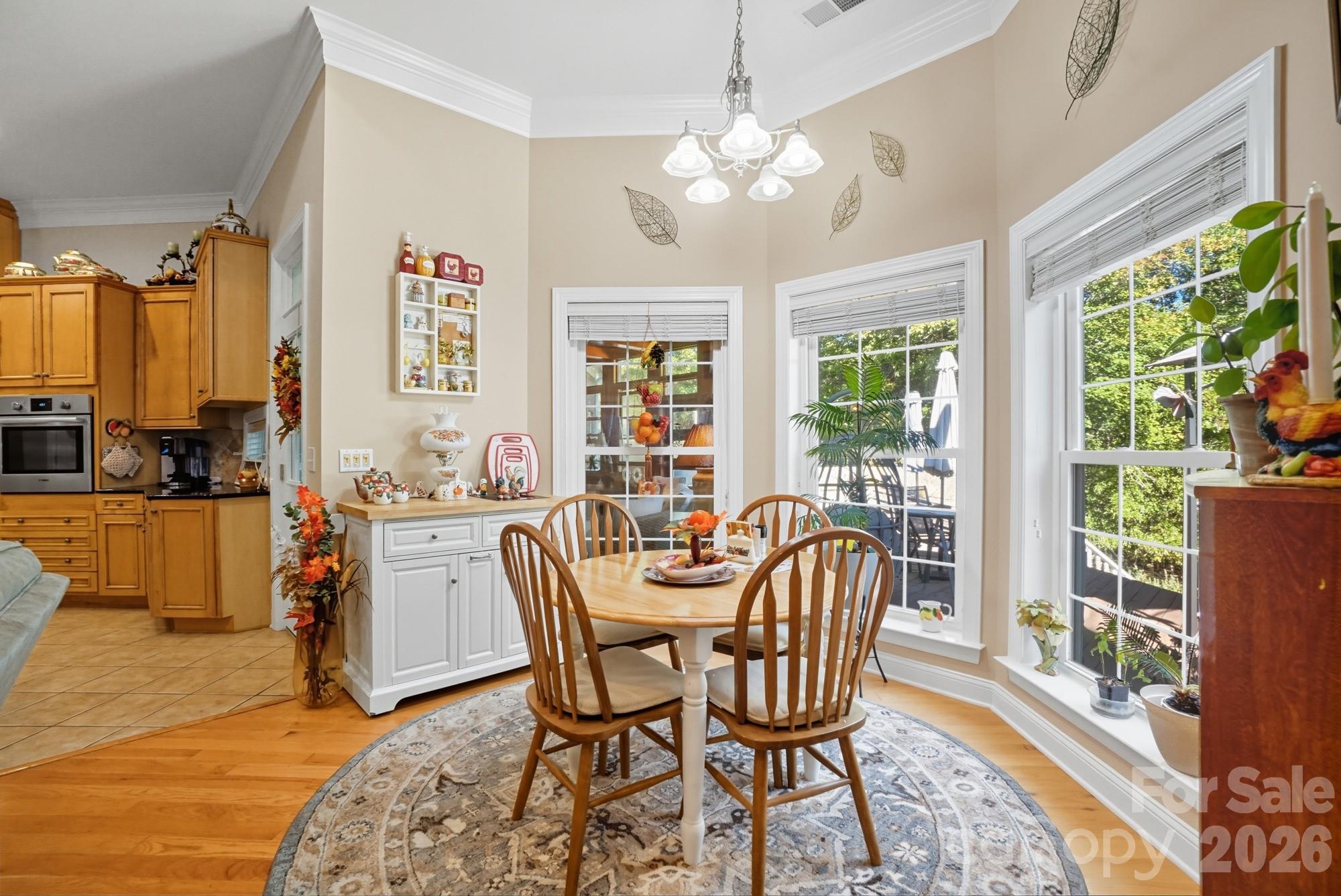 8629 Hayden Way Concord, NC 28025 - Photo 15 of 39 a dining room with furniture a chandelier and wooden floor