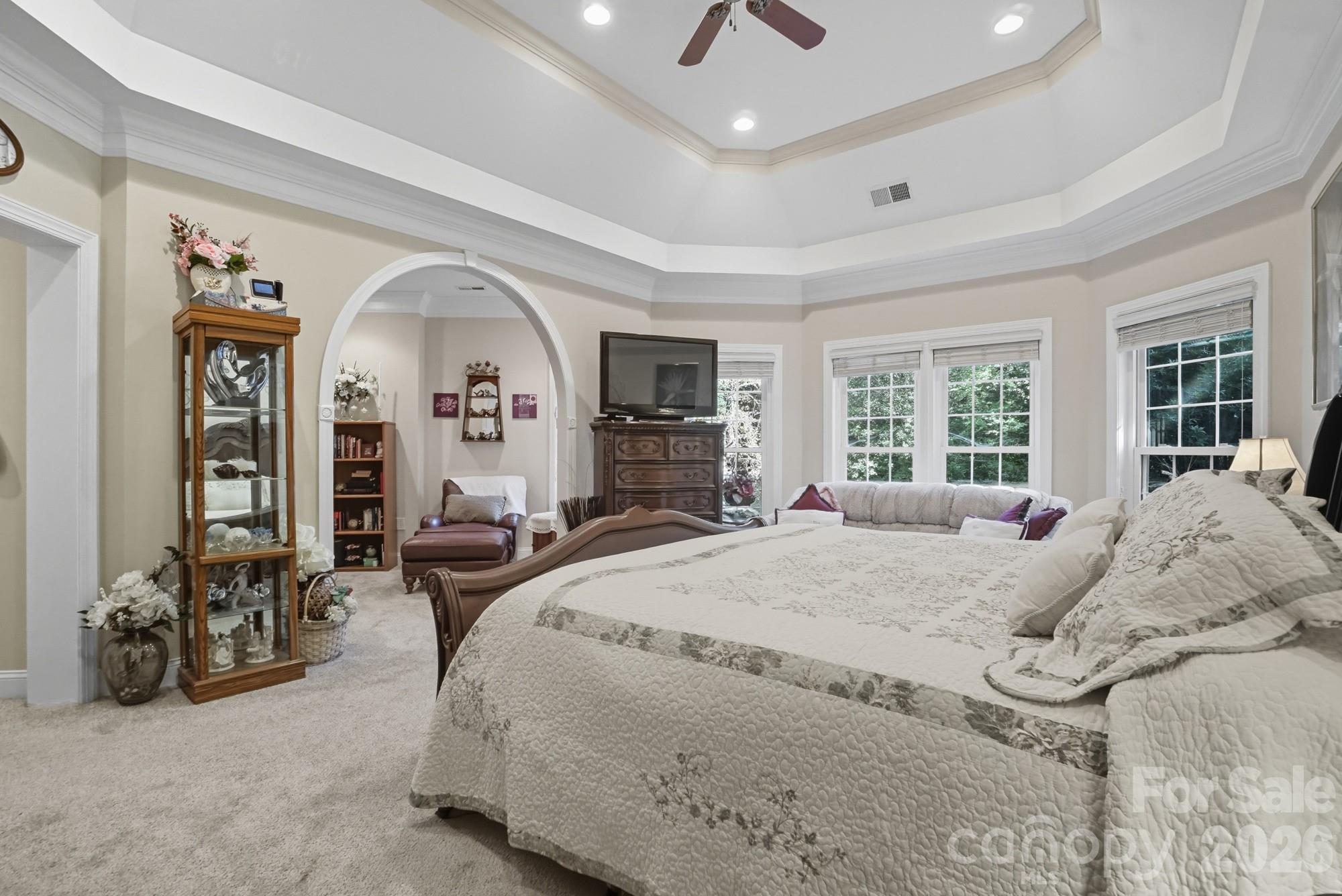 8629 Hayden Way Concord, NC 28025 - Photo 20 of 39 a spacious bedroom with a bed a mirror and windows