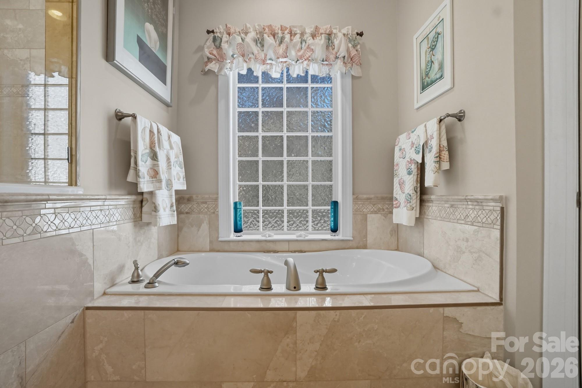 8629 Hayden Way Concord, NC 28025 - Photo 25 of 39 a bathroom with tub sink and mirror