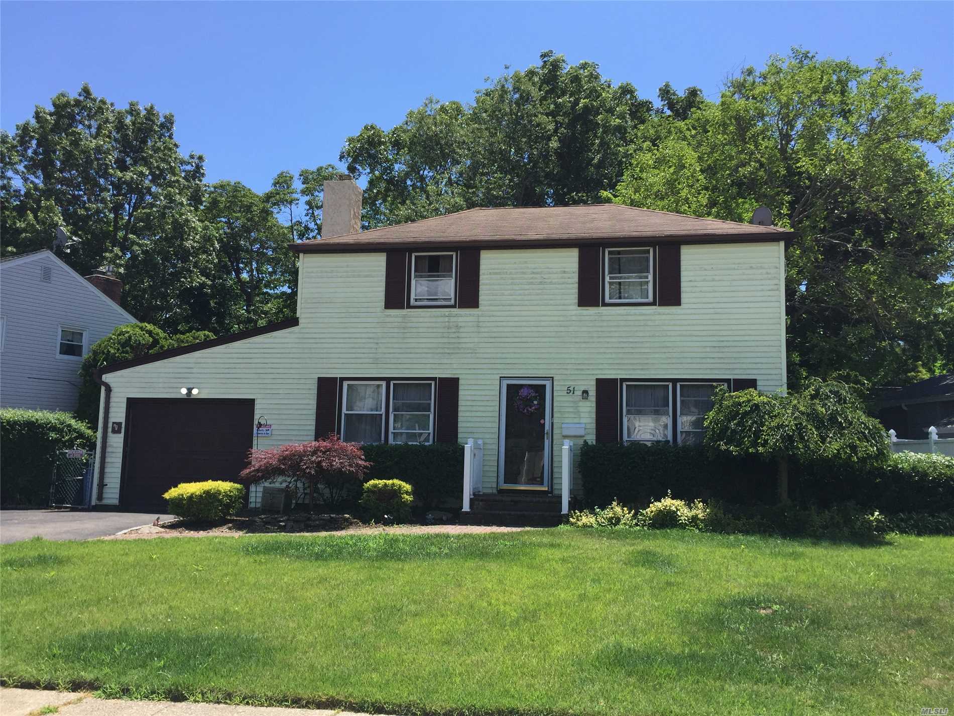 51 Crest Road East Merrick, NY 11566 - Photo 1 of 1 a front view of a house with a garden