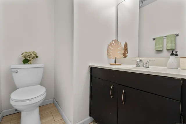 a bathroom with a sink vanity mirror and toilet