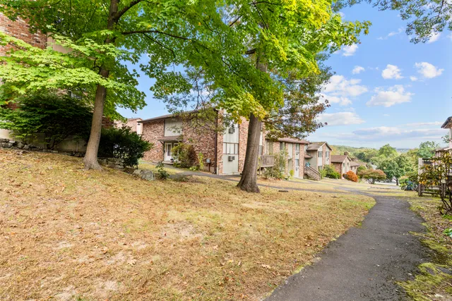 an aerial view of residential house with yard and mountain view in back