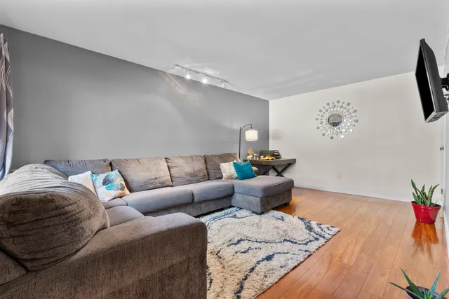 a living room with furniture and wooden floor