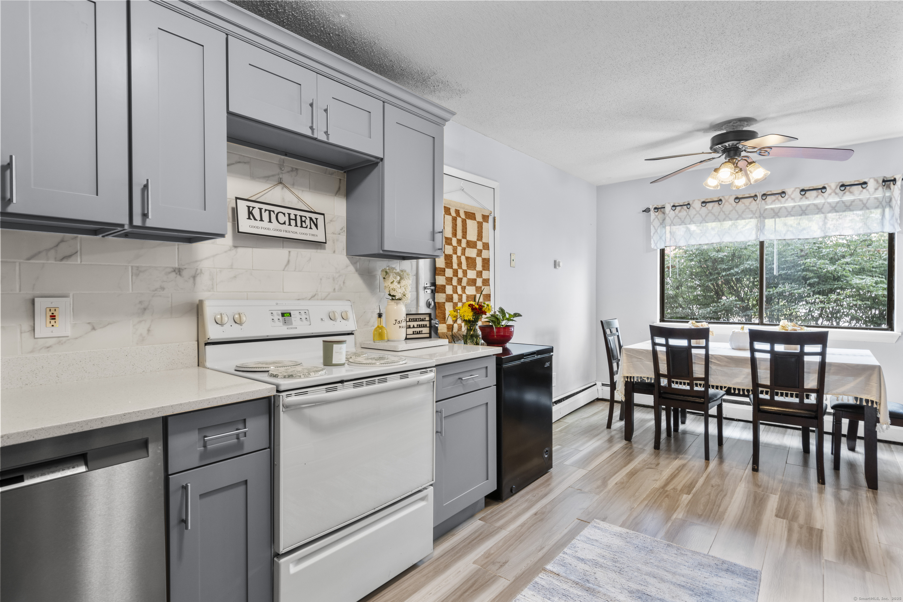 203 Kaynor Drive, Unit B Waterbury, CT 06708 - Photo 7 of 36 a kitchen with a stove a sink dishwasher white refrigerator a dining table and chairs with wooden floor