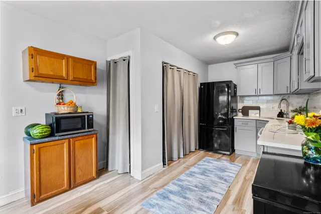 a kitchen with stainless steel appliances granite countertop a refrigerator a stove and a wooden floors