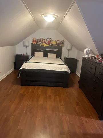 a bed sitting in a room next to a lamp