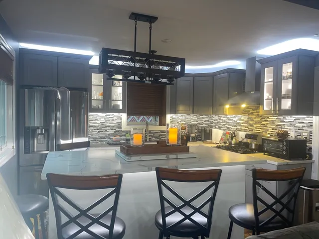 a kitchen with a dining table chairs and refrigerator