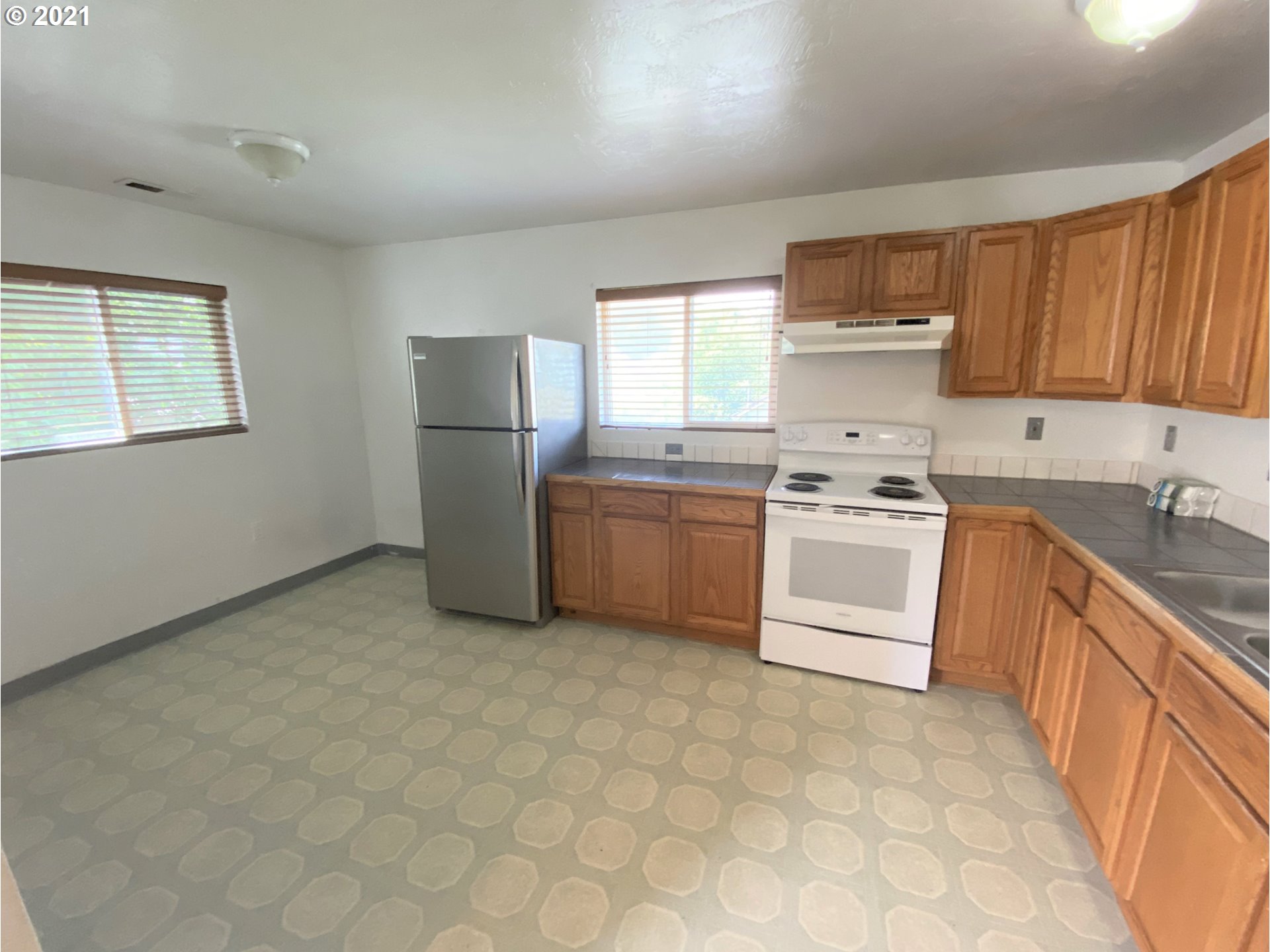 623 Southwest 4th Street Pendleton, OR 97801 - Photo 23 of 32 a kitchen with a sink a stove a refrigerator and cabinets