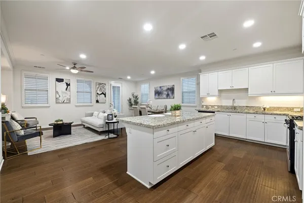 a kitchen with white cabinets and sink