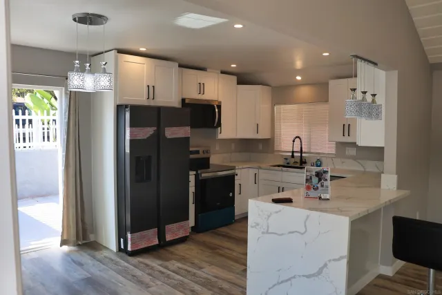 a kitchen with stainless steel appliances a refrigerator and wooden floor