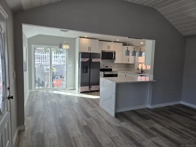 a kitchen with cabinets stainless steel appliances and wooden floor