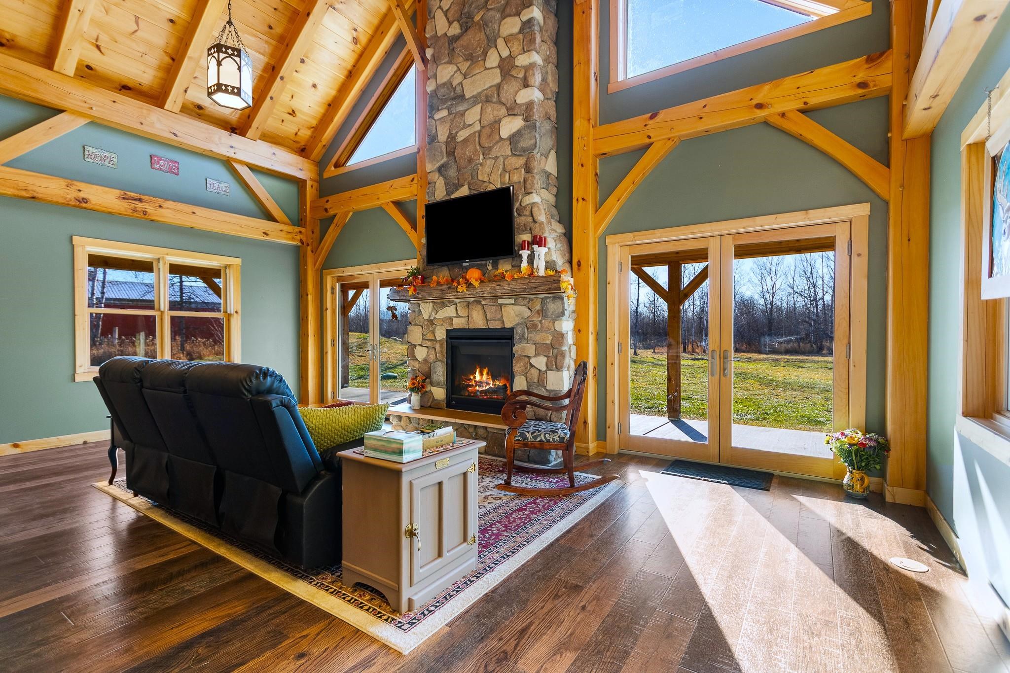6014 Brown Road Kettle River, MN 55757 - Photo 7 of 54 Living area featuring healthy amount of natural light, hardwood / wood-style floors, french doors, high vaulted ceiling, and a wooden ceiling with exposed beams
