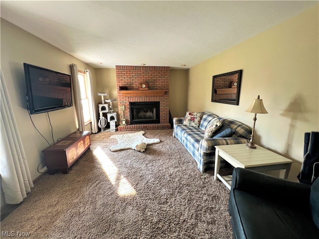 607 Bryan Road Milan, OH 44846 - Photo 13 of 34 Living room with carpet floors and brick wall