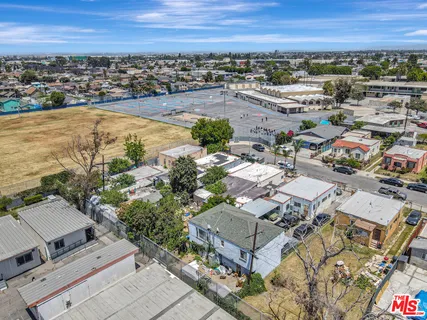an aerial view of a city with lots of residential buildings and mountain view in back