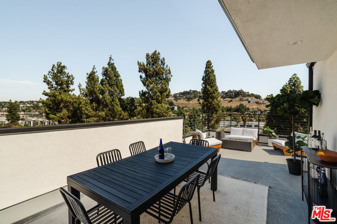 3872 North Riley Lane Los Angeles, CA 90065 - Photo 19 of 30 a view of a roof deck with dining table and chairs with wooden floor