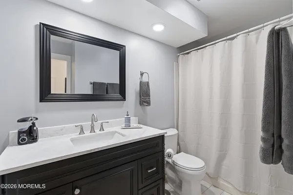 a bathroom with a granite countertop sink a toilet and a mirror