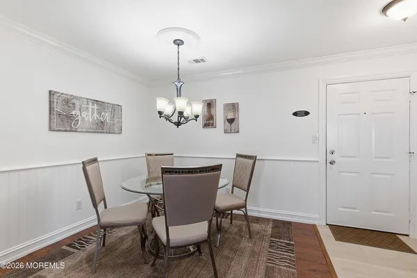 a view of a dining room with furniture wooden floor and a chandelier