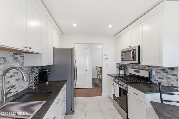 a kitchen with stainless steel appliances granite countertop a sink stove and refrigerator