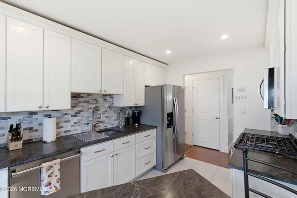 a kitchen with stainless steel appliances granite countertop a refrigerator stove and sink