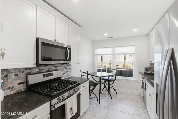 a kitchen with stainless steel appliances a stove a microwave a sink and a refrigerator