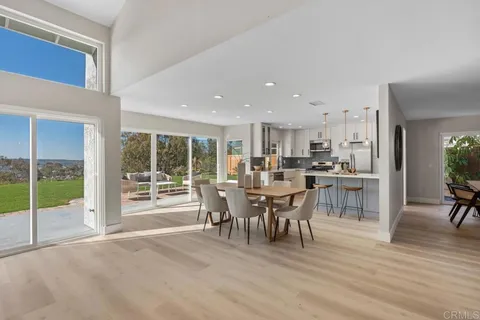 a kitchen with stainless steel appliances kitchen island granite countertop a refrigerator a stove a sink dishwasher and a stove with wooden floor