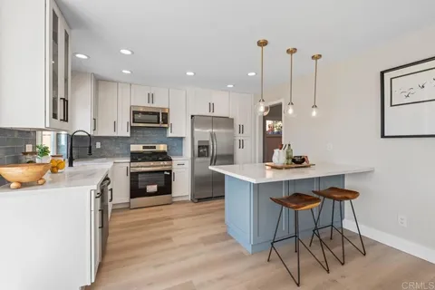 a kitchen with stainless steel appliances a sink stove and cabinets