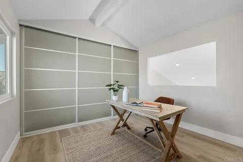 a bedroom with a large bed a painting on the wall and a window