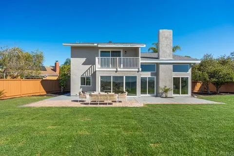 a front view of a house with a yard and potted plants