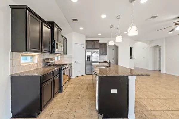 a large kitchen with stainless steel appliances kitchen island granite countertop a large counter top and stove