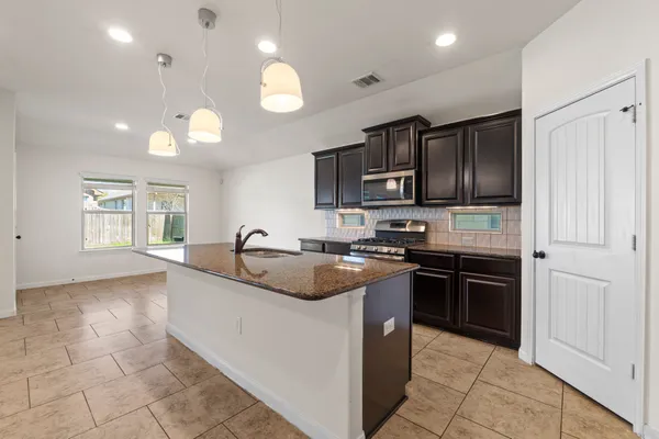 a kitchen with stainless steel appliances granite countertop a sink stove and refrigerator