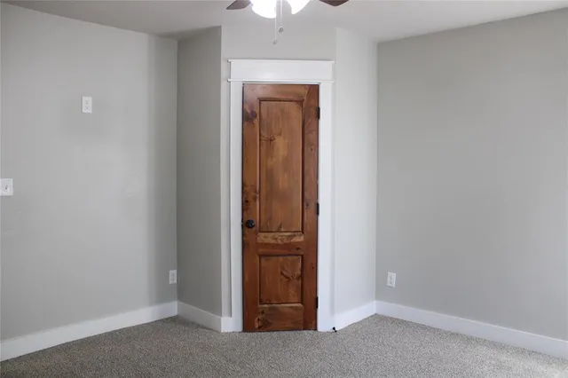 an empty room with a hallway and closet