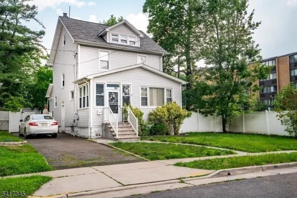 a front view of a house with a garden and plants