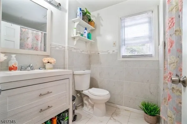 a bathroom with a sink a toilet and a shower curtain