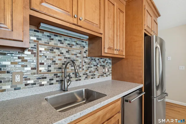 a kitchen with stainless steel appliances granite countertop a refrigerator and a stove top oven