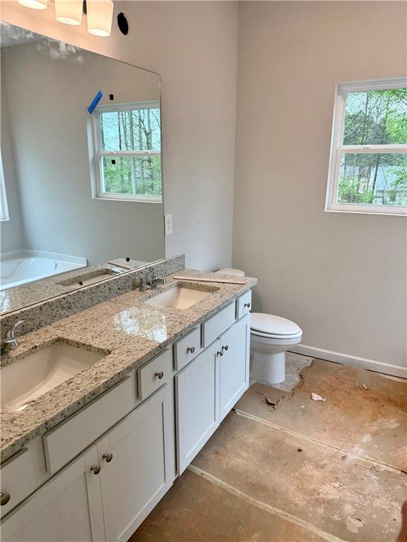 503 Charleston Place Villa Rica, GA 30180 - Photo 13 of 14 a bathroom with a granite countertop sink a toilet and a window