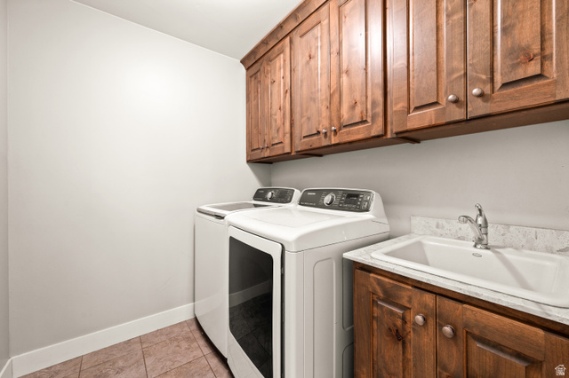 1145 North Christley Lane, Unit 48 Elk Ridge, UT 84651 - Photo 17 of 38 Laundry area featuring wood-finish cabinetry, a utility sink with a stone-finish countertop, and tile flooring