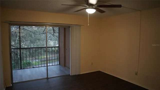en empty room with sliding glass door and a floor to ceiling window