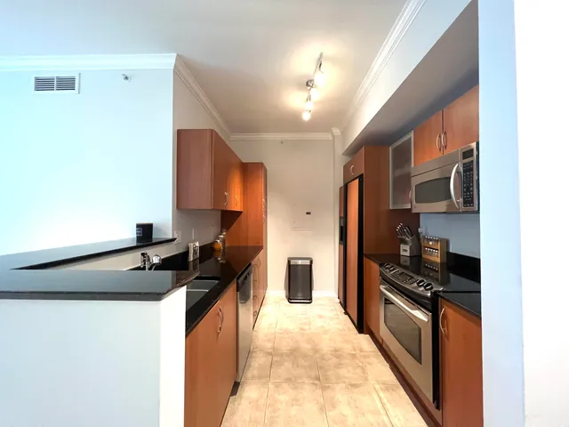 a kitchen with granite countertop a stove and a refrigerator