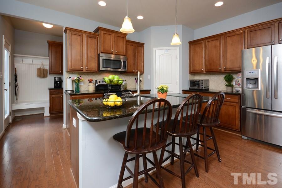 1003 Lakeview Road Durham, NC 27712 - Photo 5 of 25 a kitchen with stainless steel appliances a table chairs microwave and refrigerator
