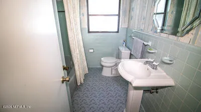a bathroom with a sink a toilet and a mirror